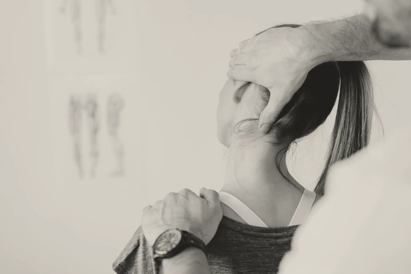 A chiropractor assessing the alignment of a patient's neck